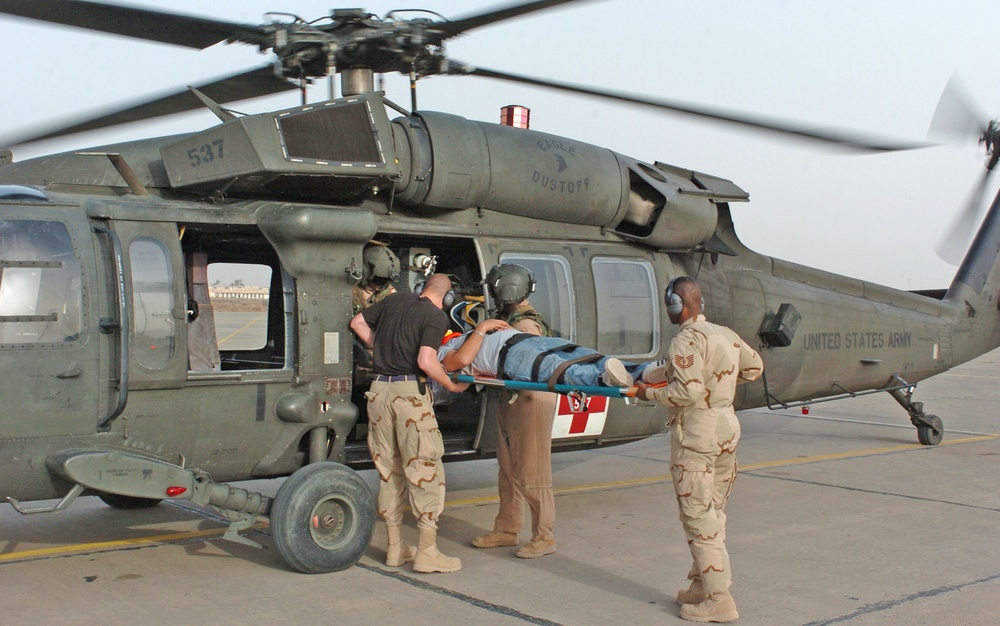 Sgt. Marcus Miller and two medics load a casualty