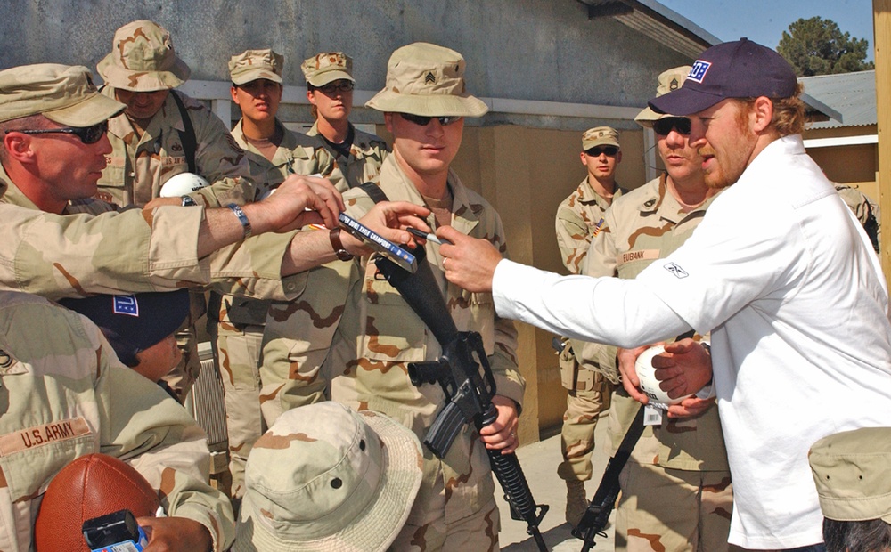 Larry Izzo hands an autographed disc to a soldier