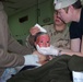 Spc. Stough holds up the head of an 18-month-old girl