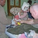 Soldiers treat an 18-monh-old girl who was badly burned