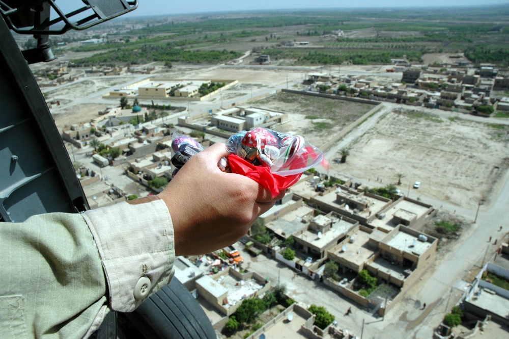 A Soldier prepare to drop a (candy bomb) from UH-60 BlackHawk