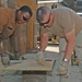 Spc. Ross and Sgt. Steiner measures a piece of metal
