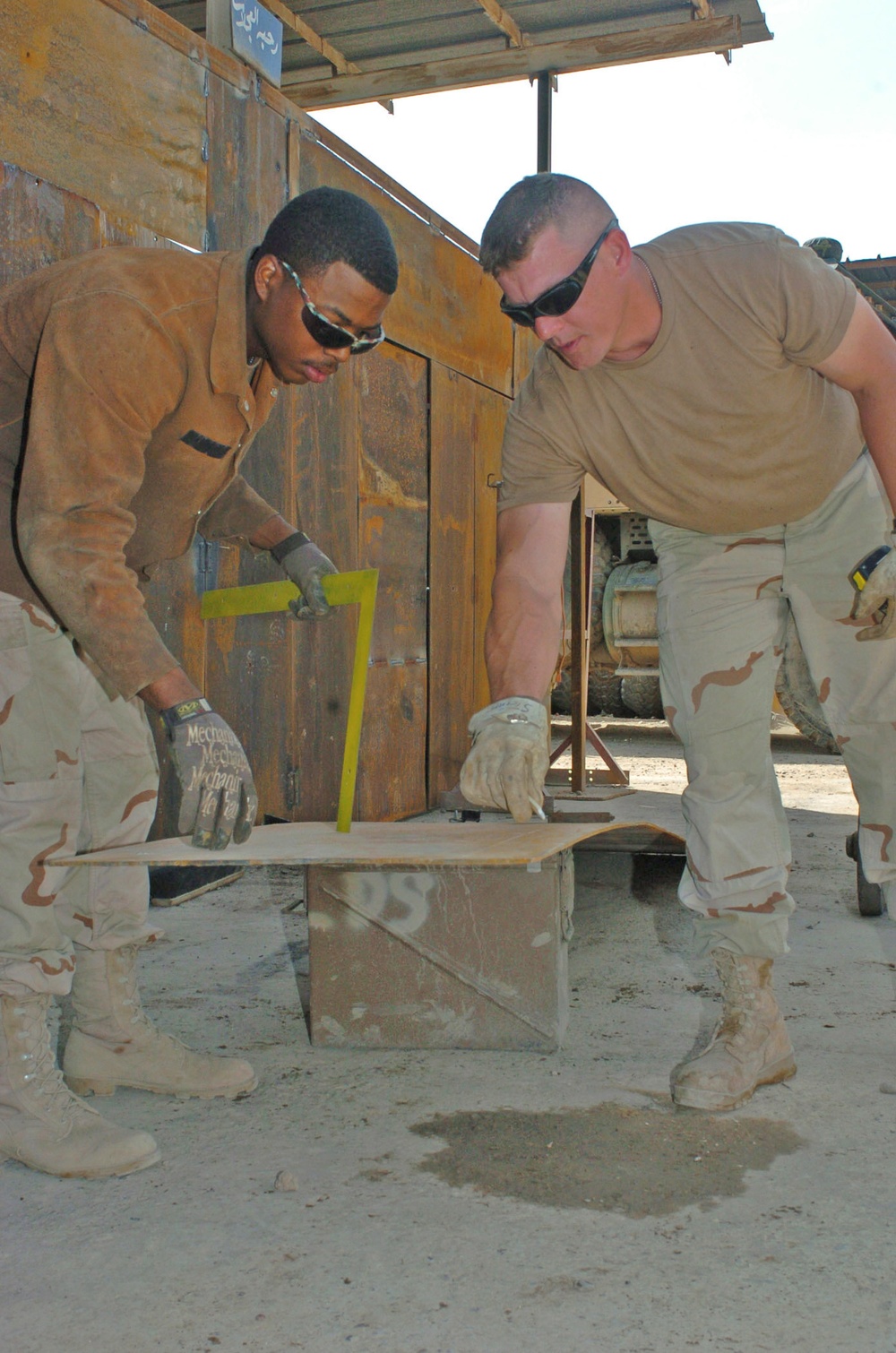 Spc. Ross and Sgt. Steiner measures a piece of metal