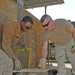 Spc. Ross and Sgt. Steiner measures a piece of metal