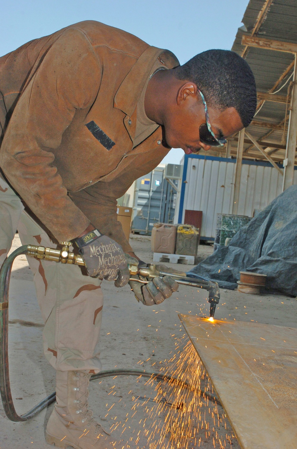 Spc. Michael D. Ross cuts out a piece of metal