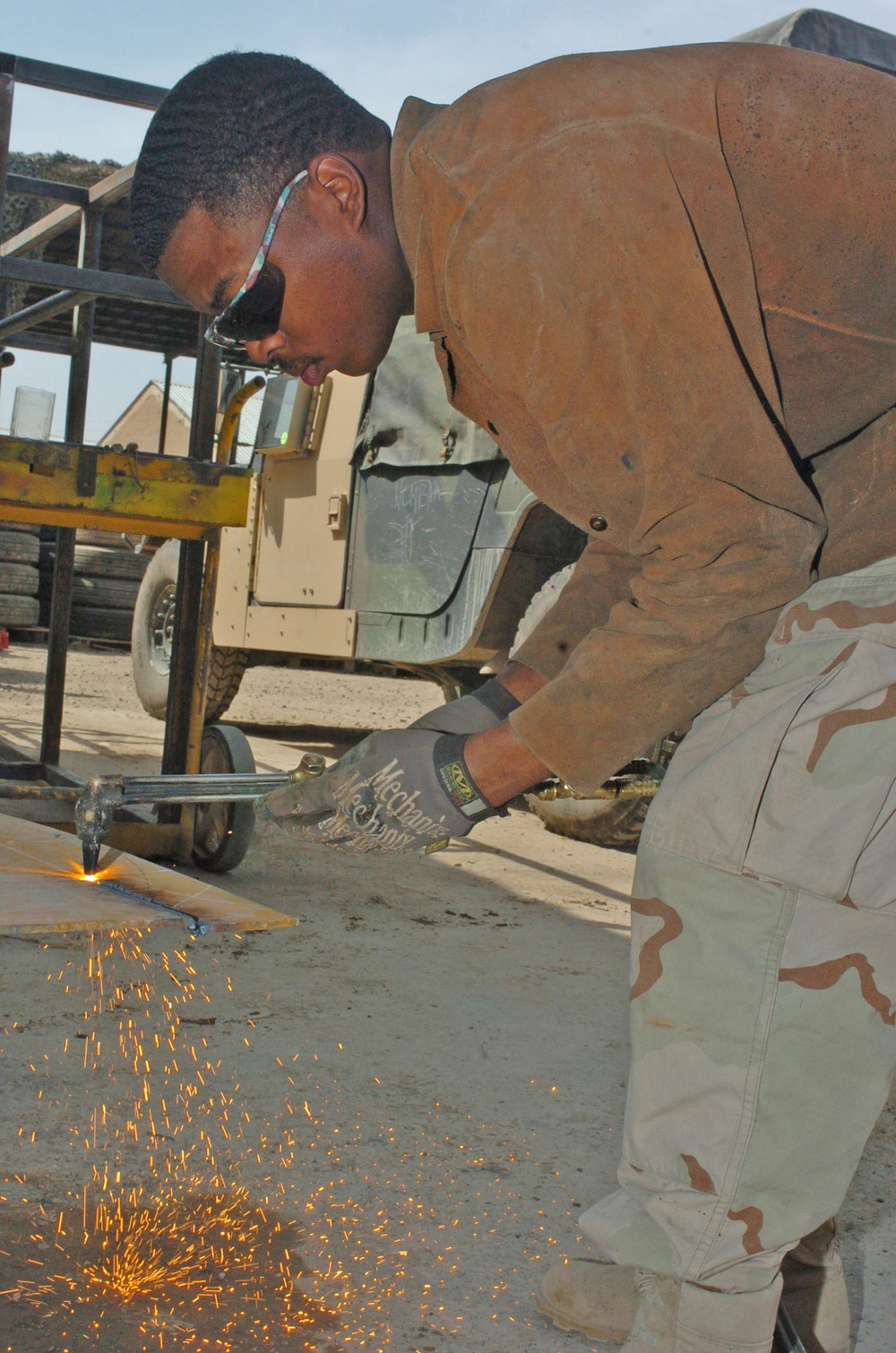 Spc. Michael D. Ross cuts out a piece of metal