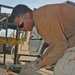 Spc. Michael D. Ross cuts out a piece of metal