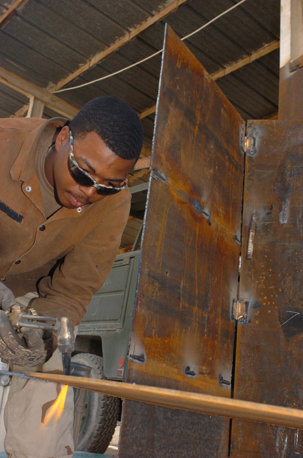 Spc. Michael D. Ross cuts out a piece of metal