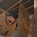 Spc. Michael D. Ross cuts out a piece of metal
