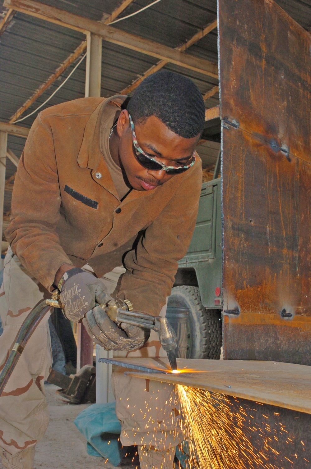 Spc. Michael D. Ross cuts out a piece of metal to use