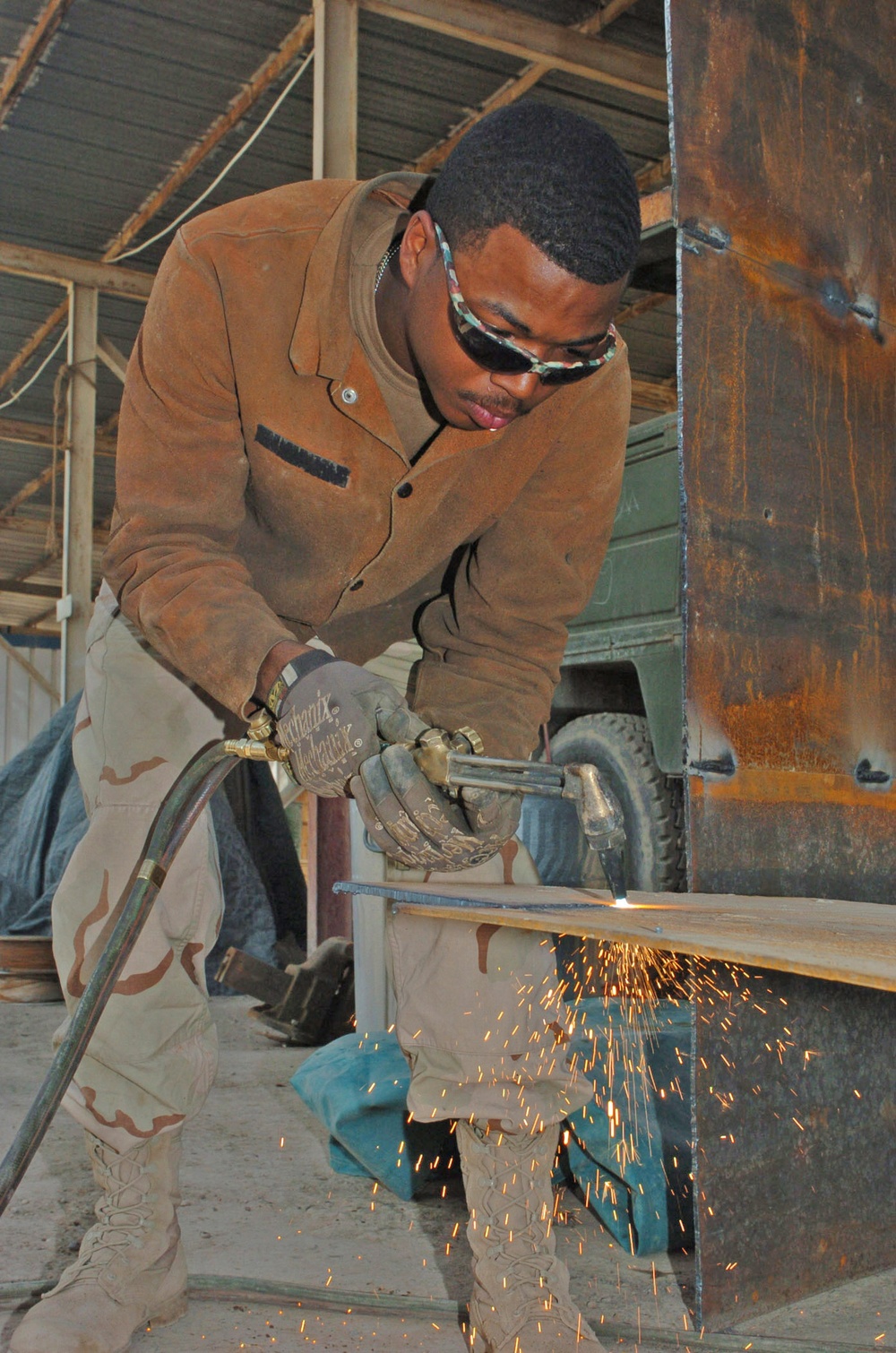 Spc. Michael D. Ross cuts out a piece of metal to use