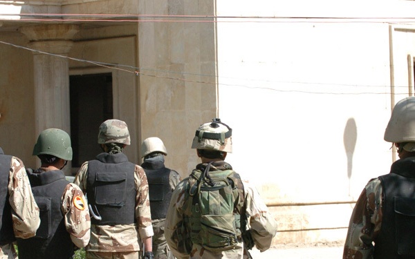 Soldiers head toward an old theater inhabited by squatters