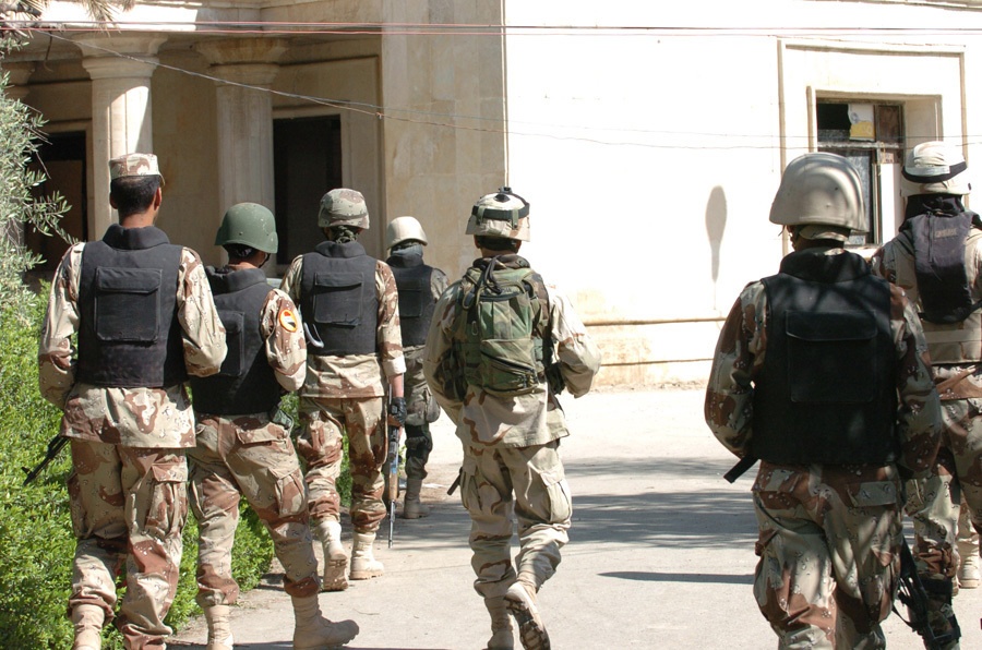 Soldiers head toward an old theater inhabited by squatters