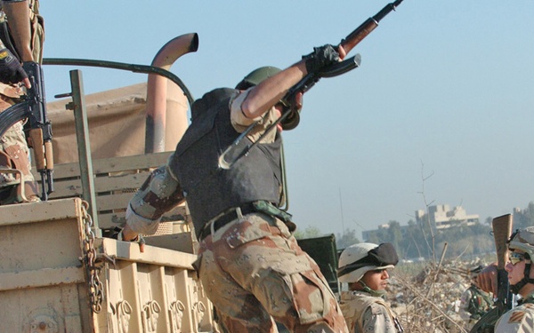 A soldier jumps out of a five-ton truck at the first stop
