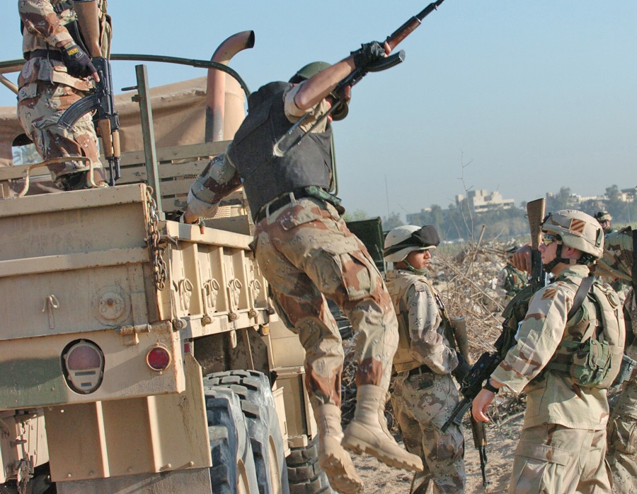 A soldier jumps out of a five-ton truck at the first stop