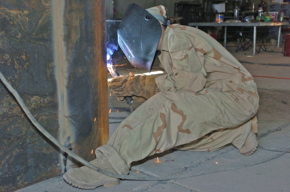 Pfc. Hollenback welds the corner of an armored box