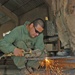 Spc. Alejandro Guevara cuts a piece of steel