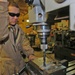 Spc. Paris uses a drill press while creating a bumper guard