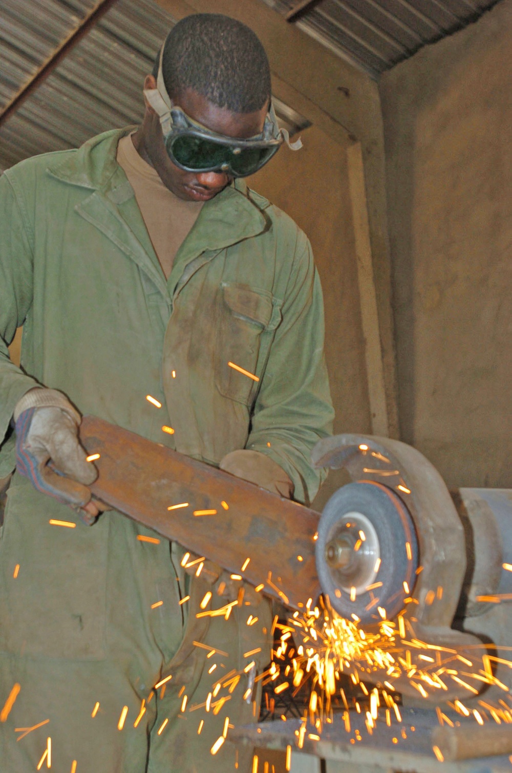 Spc. David Greer uses a grinder to smooth out the edges