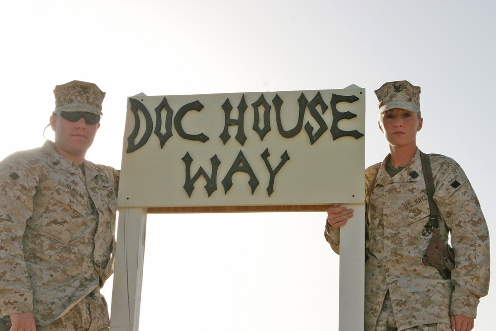 Two Soldiers stand with the road sign dedicated