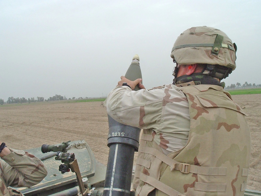 Spc. Camille Fossier hangs a round for the mortar mission
