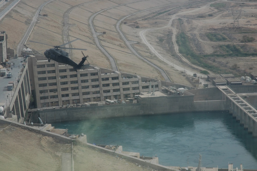 A UH-60 helicopter flies over Haditha Dam