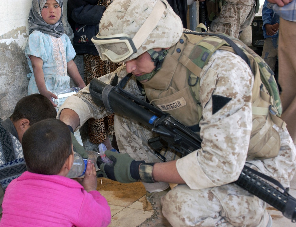 Alberto Reapegur shares water with a young Iraqi child