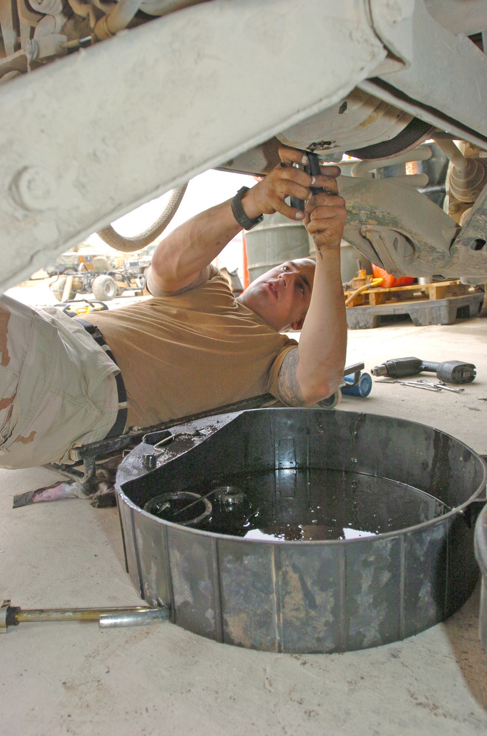 Spc. Greg Laperle removes the rear differential drain plug