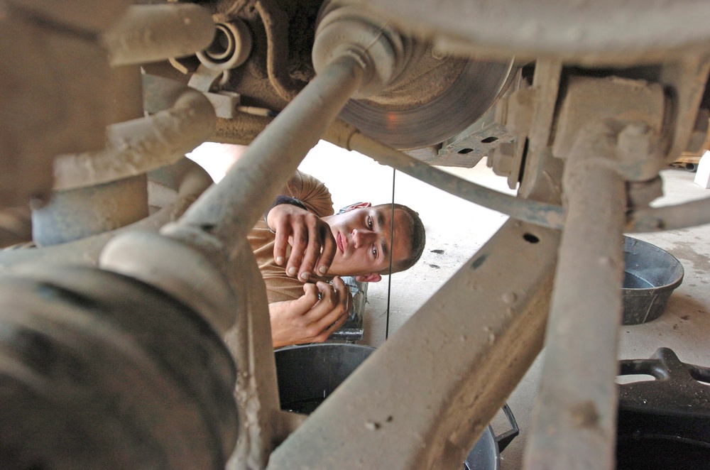 Spc. Greg Laperle watches the oil drain from his Humvee