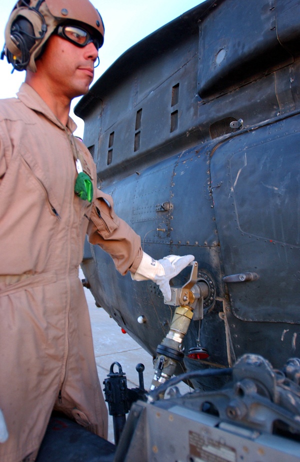 A Soldier refuel a OH-58 Kiowa Warrior