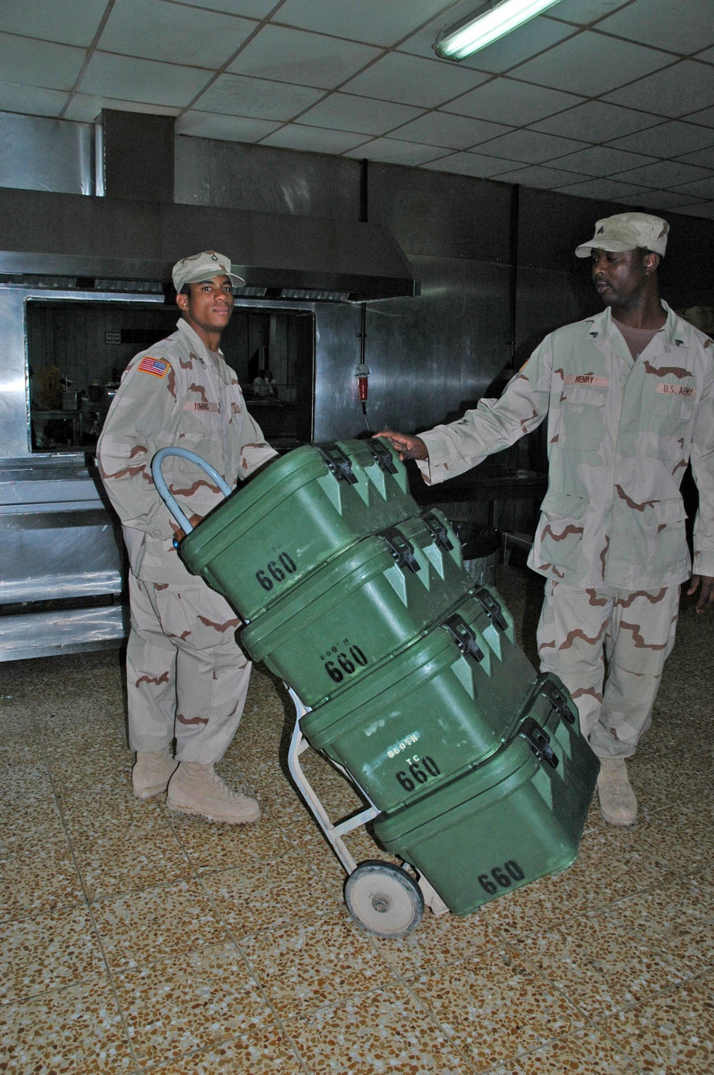 Two Soldiers move portable food storage containers