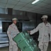 Two Soldiers move portable food storage containers