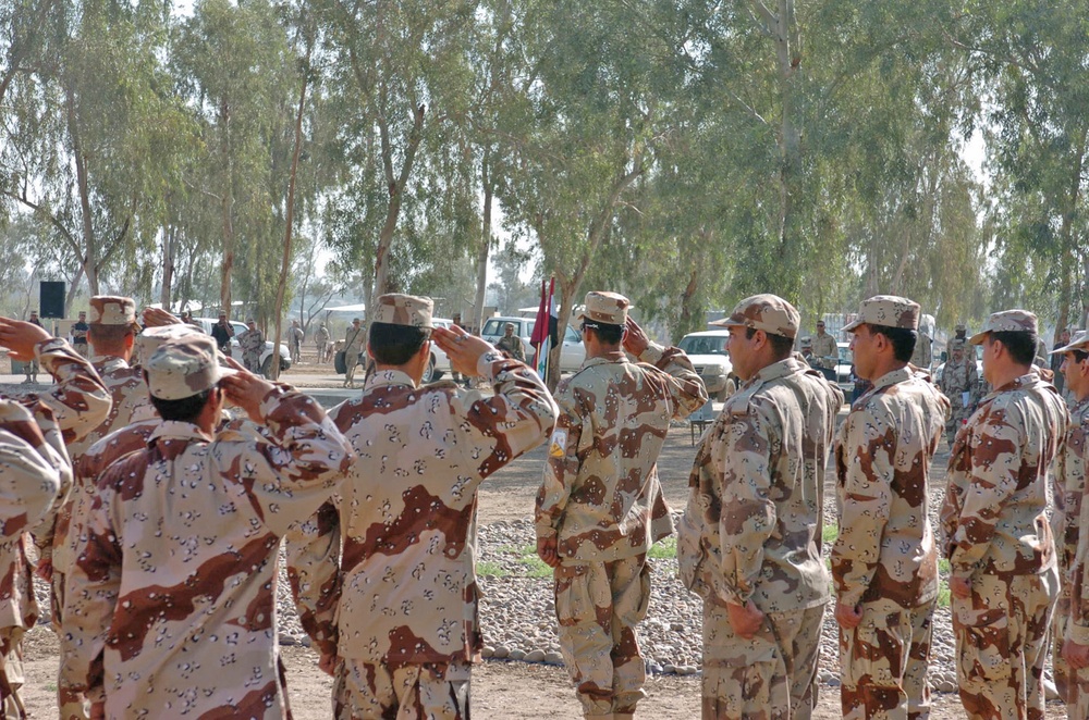 Soldiers salute the Iraqi flag