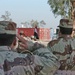 Soldiers salute the Iraqi flag during the playing of the Anthem