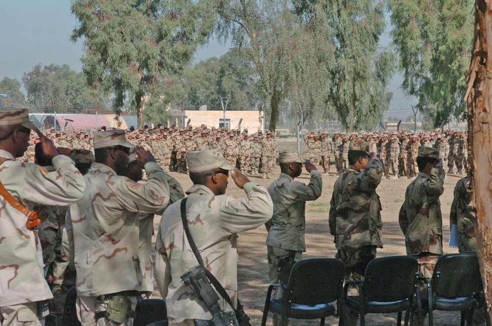 Soldiers of the Iraqi Army salute the Iraqi flag