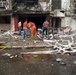 Iraqi firefighters work together and survey the damage