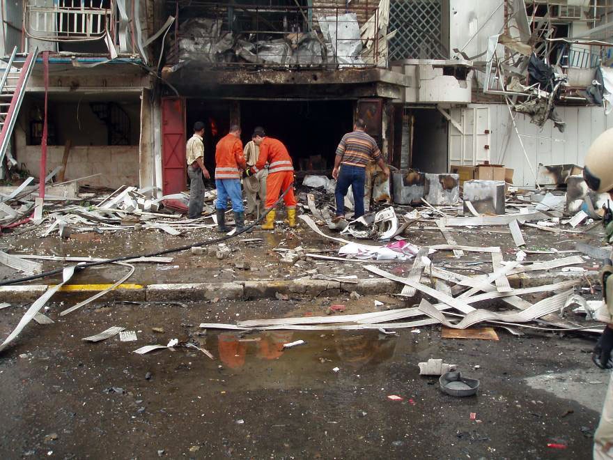 Iraqi firefighters work together and survey the damage