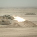 A tank crew engages a target with its 120 mm main gun