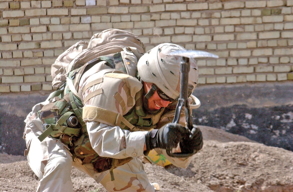 Sgt. Ruben Paredes digs after an engineer detects metal