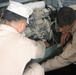 Two soldiers change the oil in one of the many generators