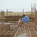Iraqi workmen tie lengths of rebar together