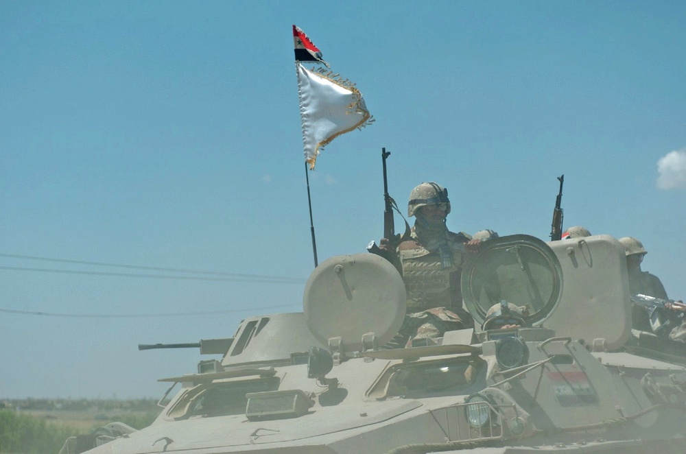 An Iraqi Soldier stands ready in the turret of his MTLB