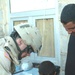 1st Lt. Colomb draws a heart on the hand of an child