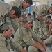 Iraqi police place bandages around each others heads