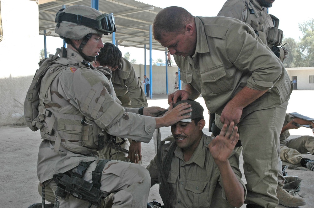 PFC Ringman assist two Iraqi police in proper techniques