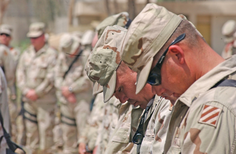 Soldiers bow their heads during the memorial service