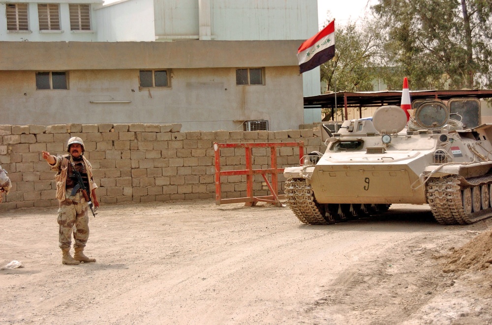 An Iraqi Soldier directs an MTLB armored personnel carrier