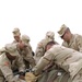 Soldiers try to stuff a large drash tent into its cargo bag