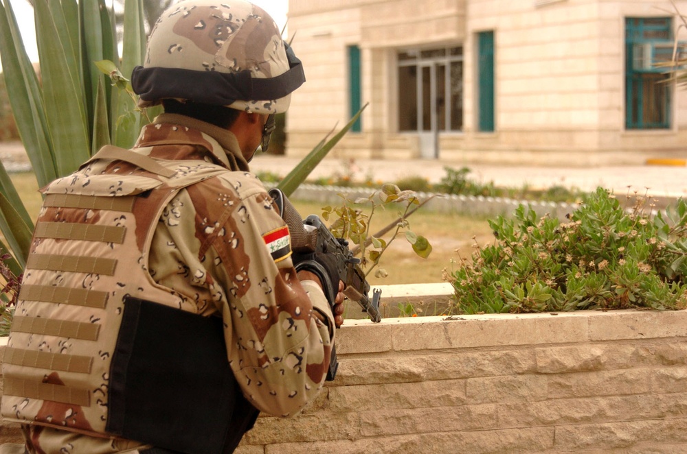 An Iraqi Soldier covers a window