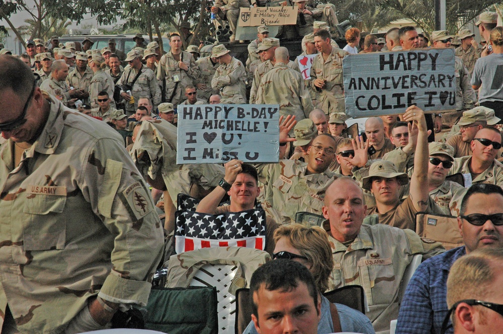 Soldiers hold up signs while waiting for Toby Keith